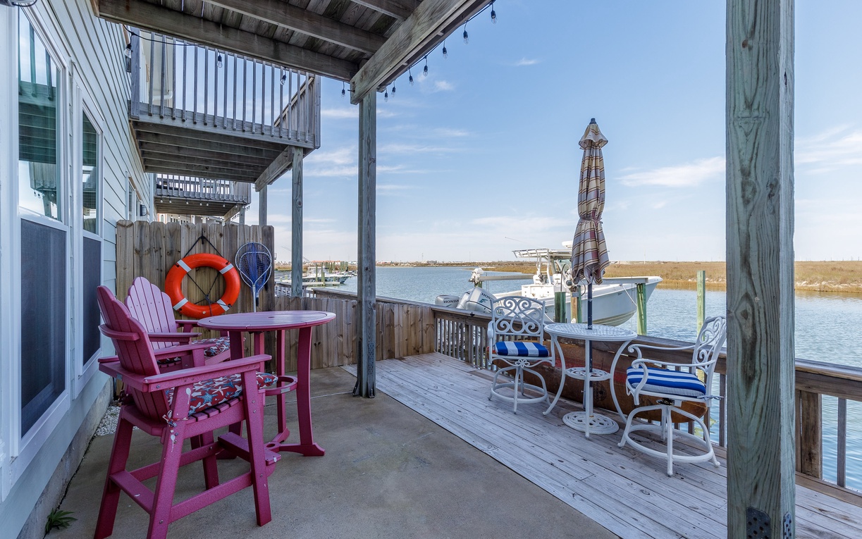 Your private waterfront deck offers front-row seats to serene water views, complete with colorful seating and direct boat access.