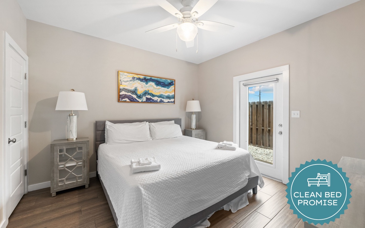 Step into your serene bedroom retreat with soft neutral tones, plush bedding, and a gentle ceiling fan to keep you cool. The private door leads you to an outdoor space where you can start your mornings with fresh air.