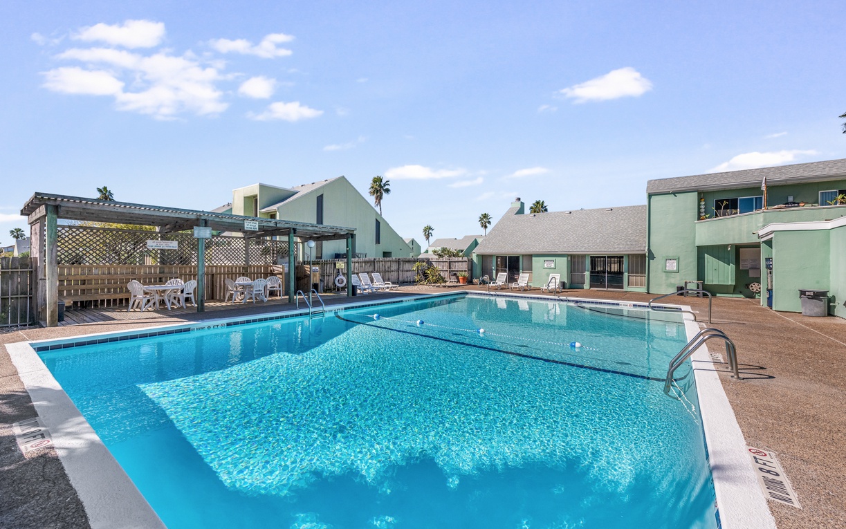 Sparkling pool area with covered seating and tropical palms creates the perfect California retreat for your sunny getaway.