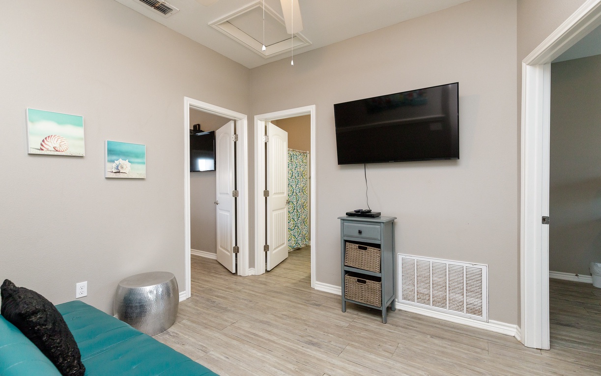 Unwind in your bright, airy living space with coastal artwork and modern entertainment center for cozy movie nights.
