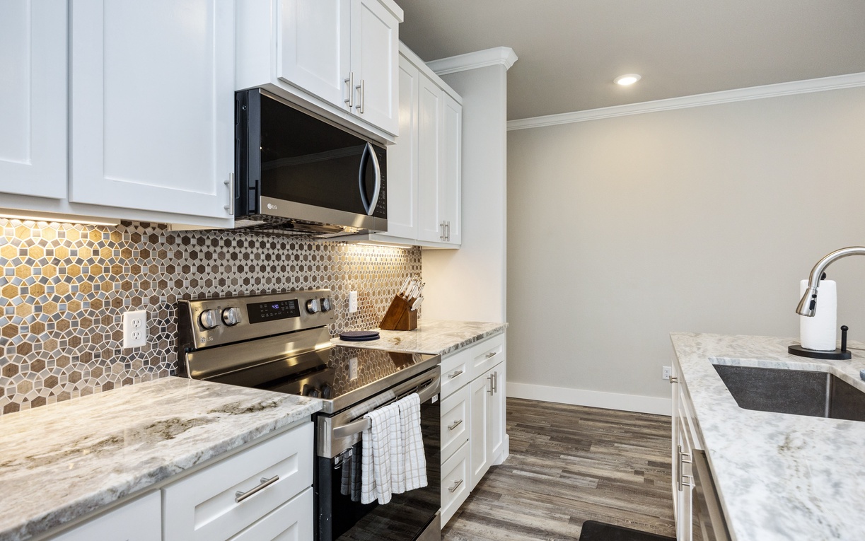 Your fully equipped kitchen features marble countertops, modern appliances, and stylish tile backsplash for memorable meal preparation.