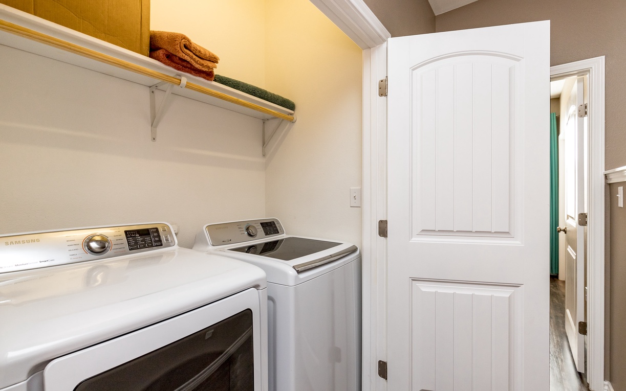 Your private laundry room features full-size washer and dryer with convenient upper storage and fresh towels ready for use.