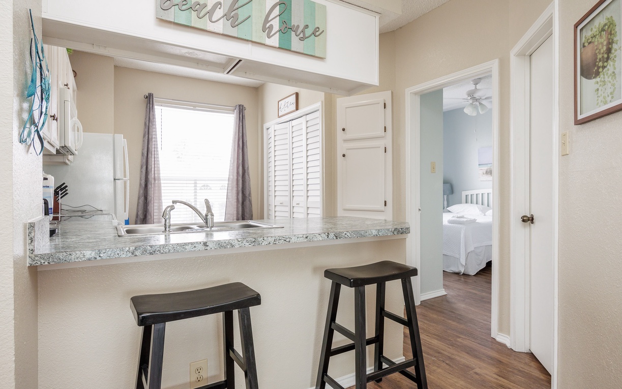Your bright kitchenette features granite counters and bar seating, perfect for morning coffee or quick meals before beach adventures.
