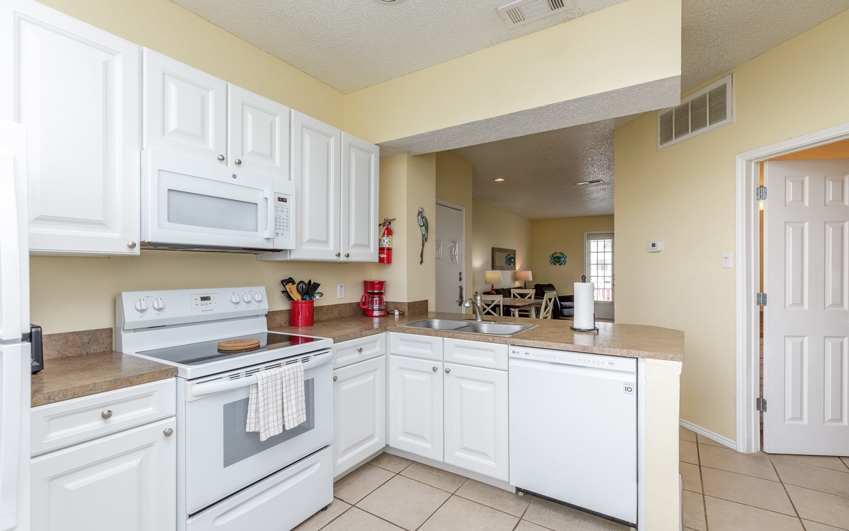 Your fully equipped kitchen awaits with white appliances, granite counters, and everything needed for home-cooked meals during your stay.