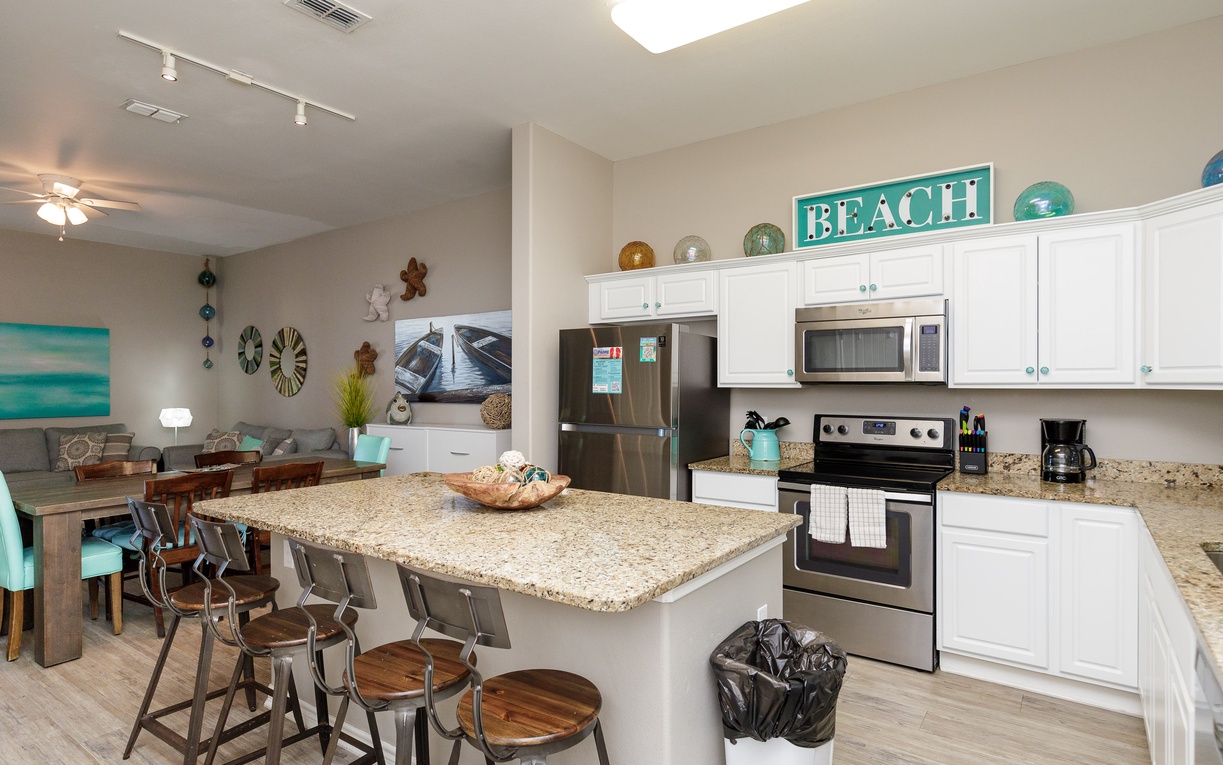 Your fully equipped kitchen flows seamlessly into the dining area, perfect for preparing beach-inspired meals together.