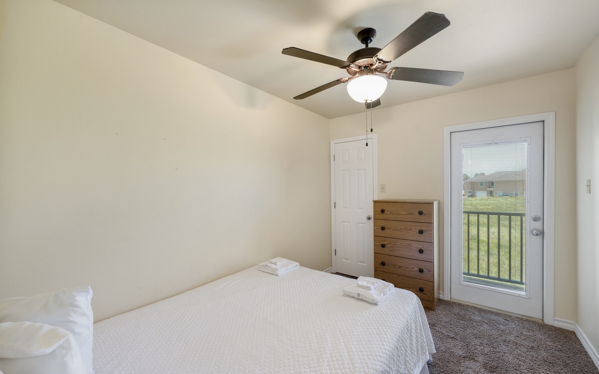 Your serene bedroom features a comfortable bed, a ceiling fan for comfort, and your own private balcony where you can step out and take in the views.