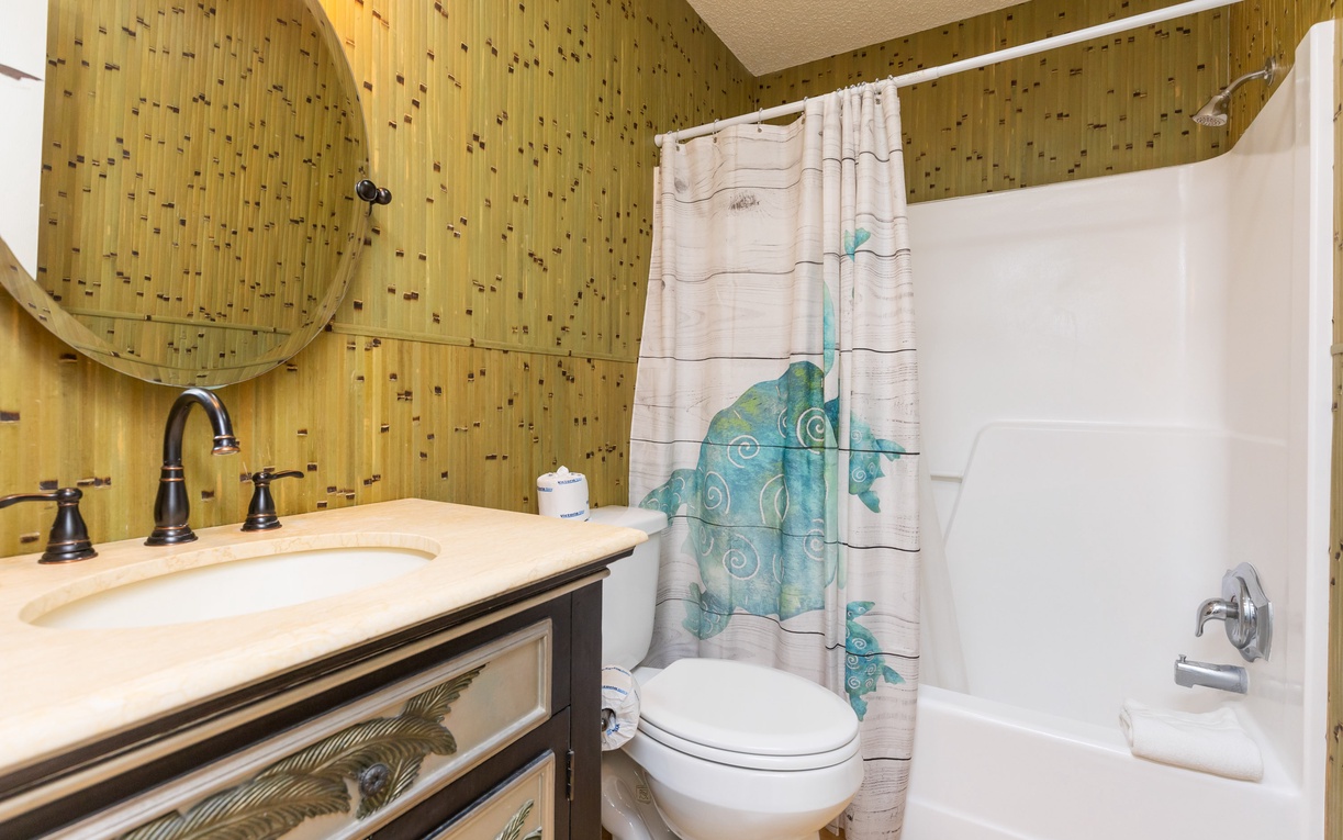 Refresh in your private bathroom with sea turtle charm and warm wood accents creating a cozy coastal retreat.