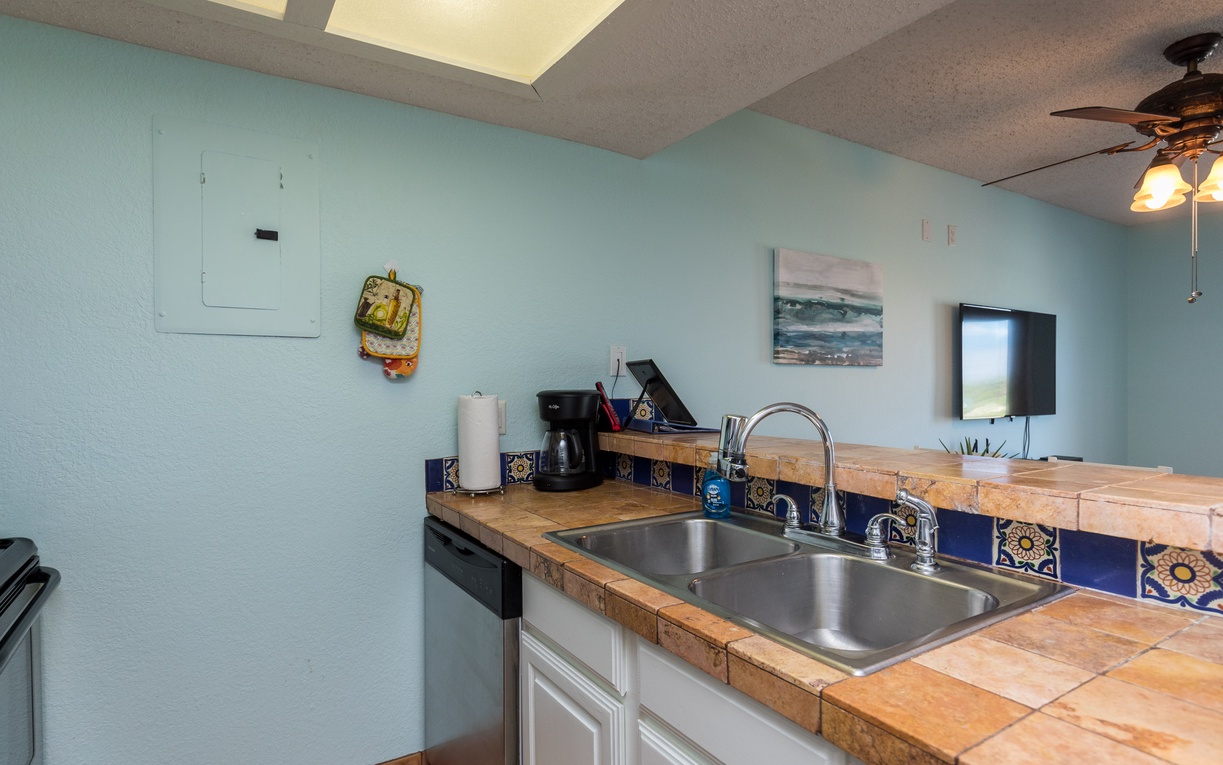 Your fully equipped kitchen features charming tile countertops, beautiful blue backsplash tiles, and everything you need for memorable meals together.