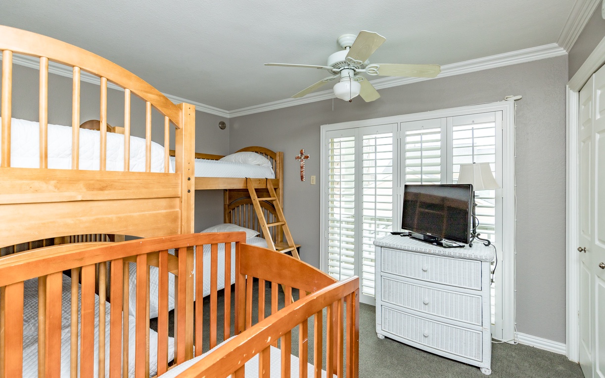 Rest comfortably in this charming bedroom featuring cozy bunk beds and modern entertainment setup for your perfect family getaway.