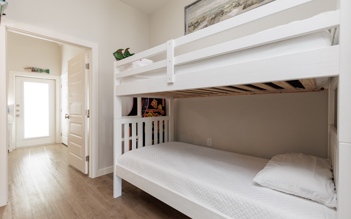 Your kids will love this bright bunk bed room with clean white linens and fun touches like colorful books for bedtime stories.