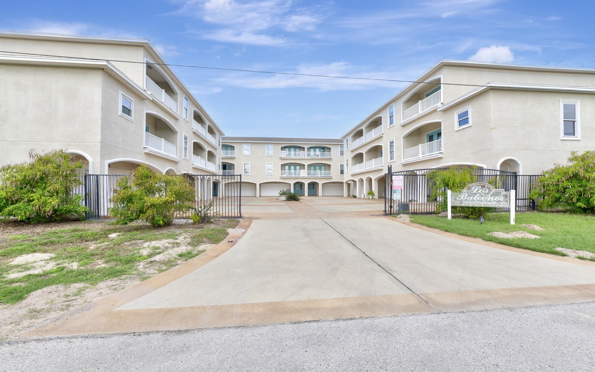 Modern gated property complex with Mediterranean-style architecture, landscaped grounds, and convenient parking access for guests.