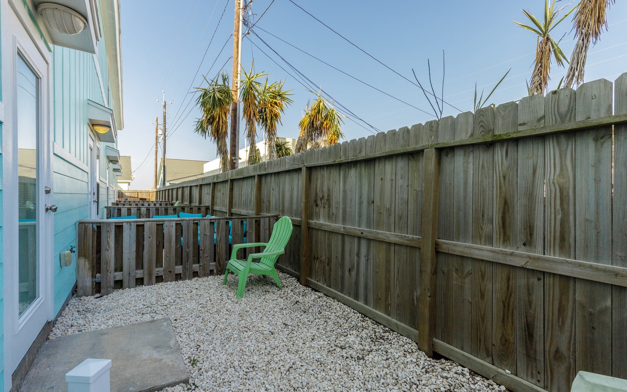 Your private outdoor space features a cozy patio with seating where you can unwind under swaying palms and clear blue skies.