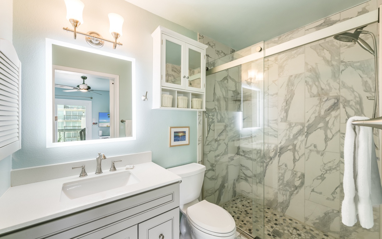 Step into your spa-like bathroom with elegant marble shower, soothing coastal colors, and thoughtful touches like plush towels and soft lighting—perfectly designed for your relaxation.