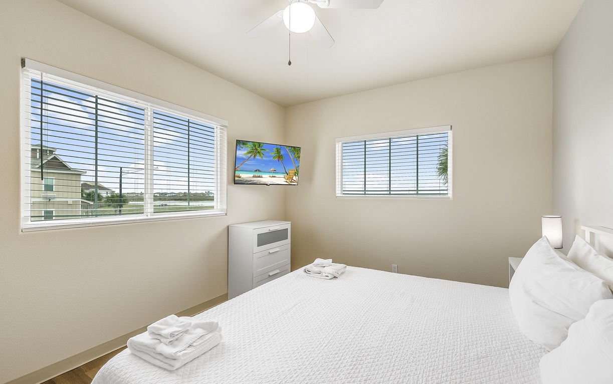 Sink into crisp white linens while gentle breezes from your ceiling fan cool you. Fresh towels await your arrival in this peaceful retreat.