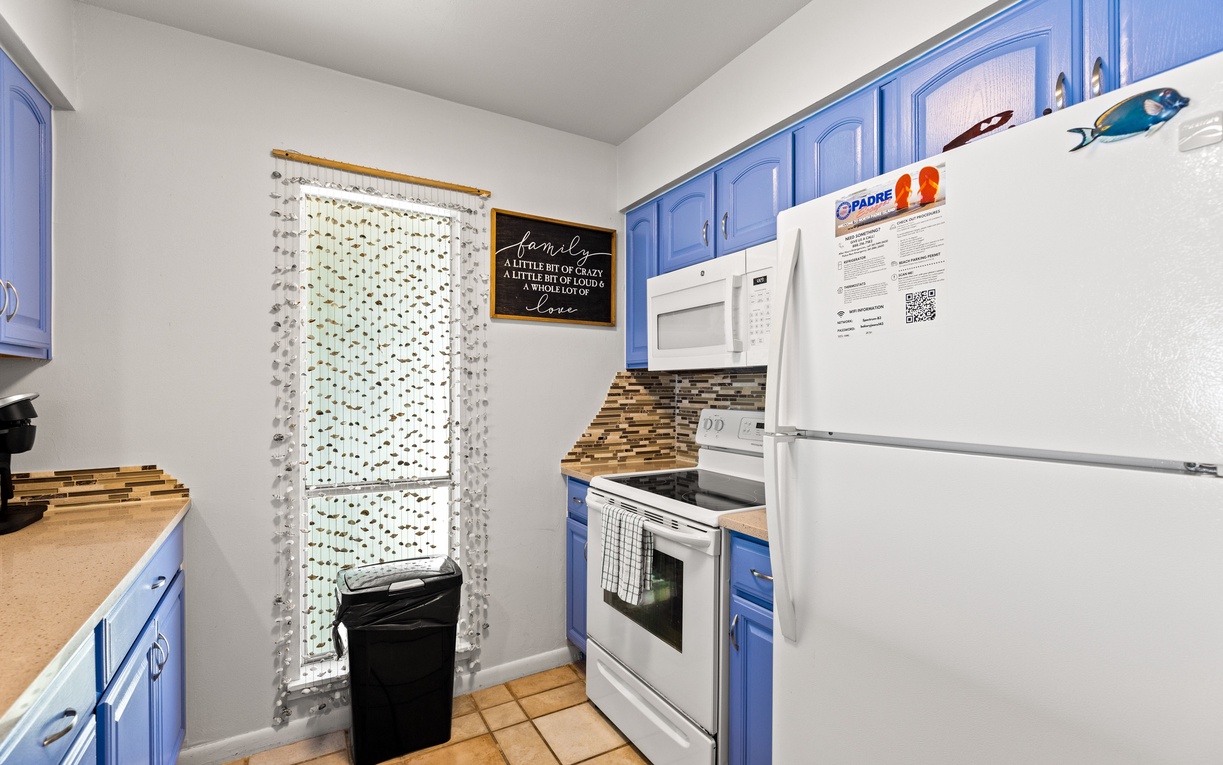 Your charming kitchen features vibrant blue cabinets, full appliances, and thoughtful touches that make cooking feel like home.