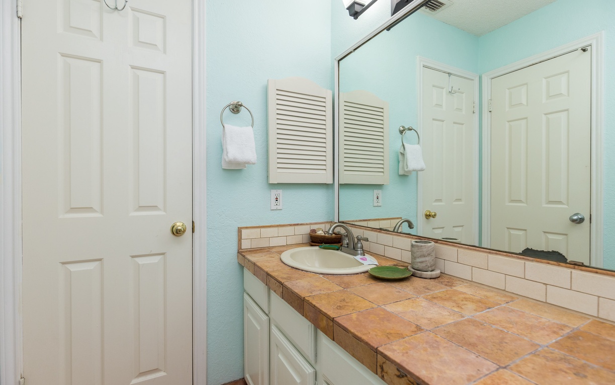 Your bathroom features soothing mint walls and spacious tile counters with everything you need for a refreshing start to your day.