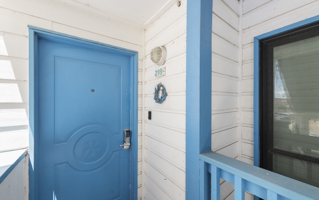 Charming coastal entrance with bright blue door and nautical touches welcomes you to your seaside retreat.