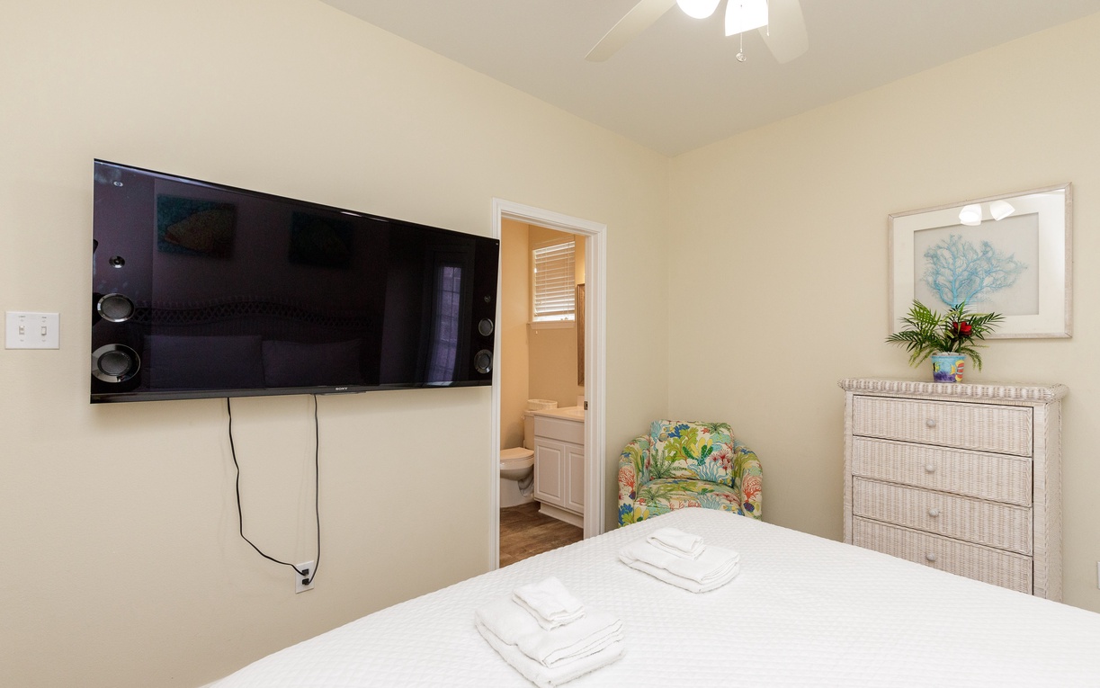 Sink into your comfortable bed while enjoying the flat-screen TV and tropical touches in this peaceful bedroom retreat.