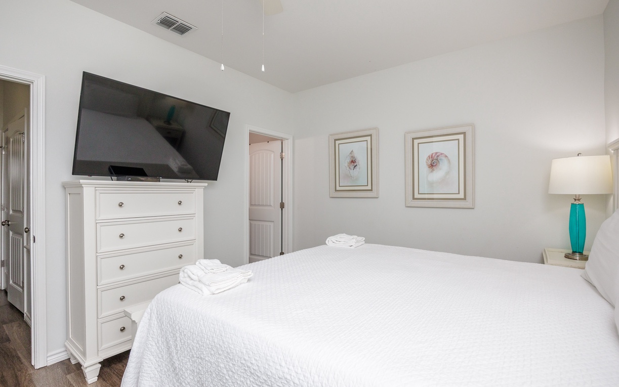 Your bright bedroom offers crisp white linens and a large TV for relaxing evenings in.