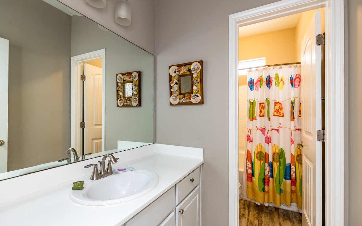 Refresh in this charming bathroom with coastal mirrors and a fun kids' shower curtain perfect for family getaways.