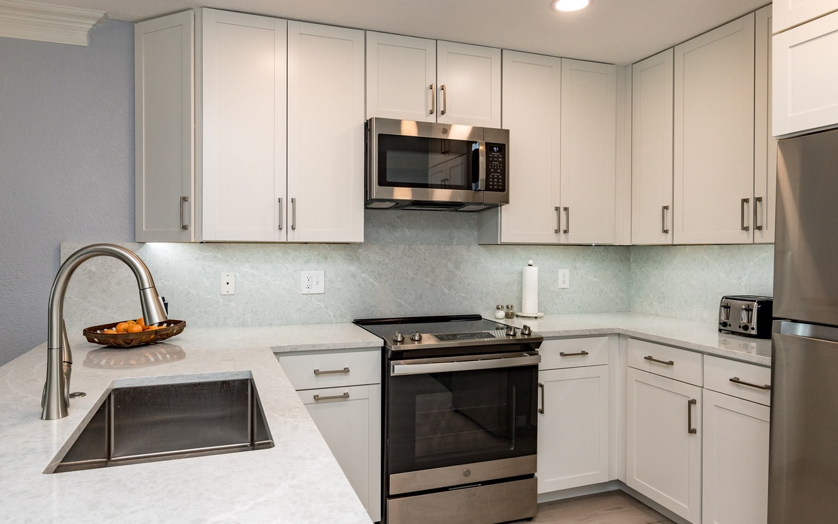 Your modern kitchen features pristine white cabinets, sleek stainless appliances, and gleaming countertops perfect for preparing meals during your stay.