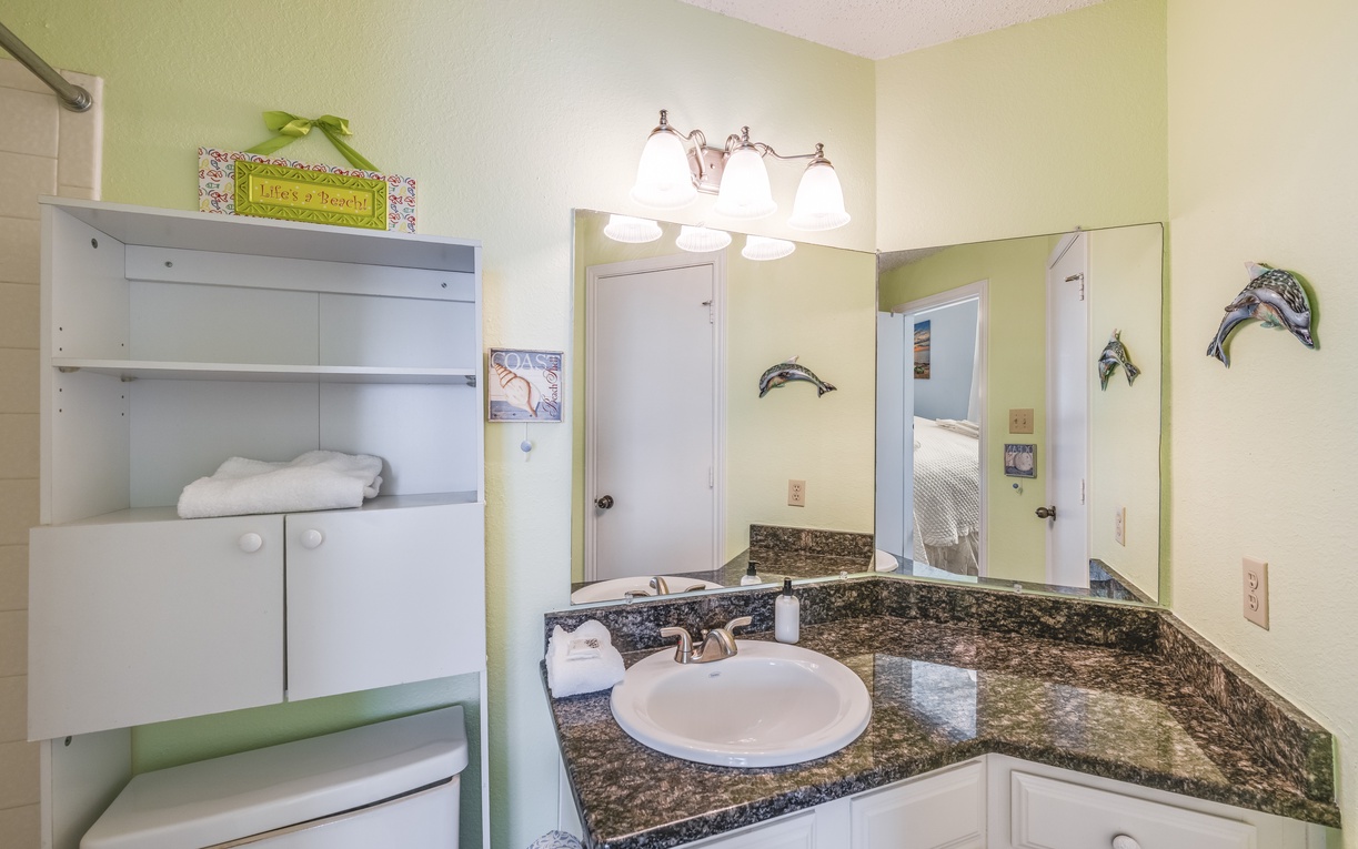 Bright guest bathroom with granite countertops, generous vanity space, and fresh towels for a comfortable stay.