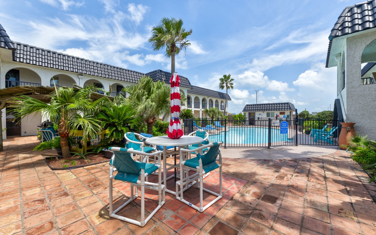 Enjoy meals al fresco at your private patio table, surrounded by tropical palms with pool access just steps away.