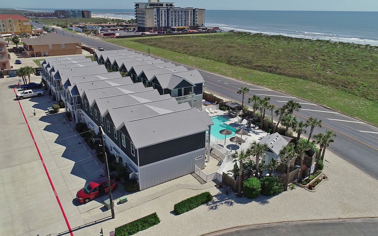 Beachfront vacation rental complex featuring pool amenities and coastal access near hotels and ocean views.