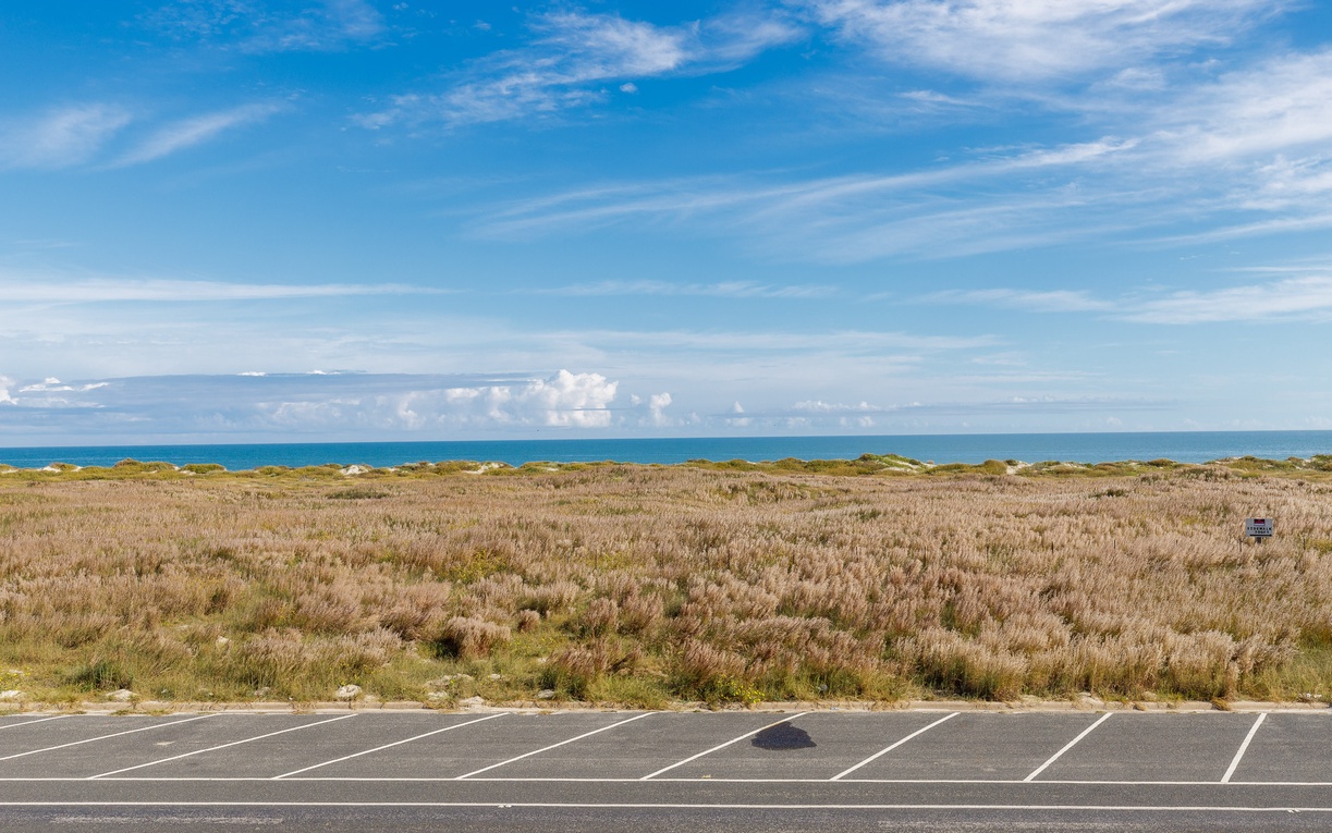 Convenient roadside parking provides easy access to coastal dunes and ocean views just steps from the property.