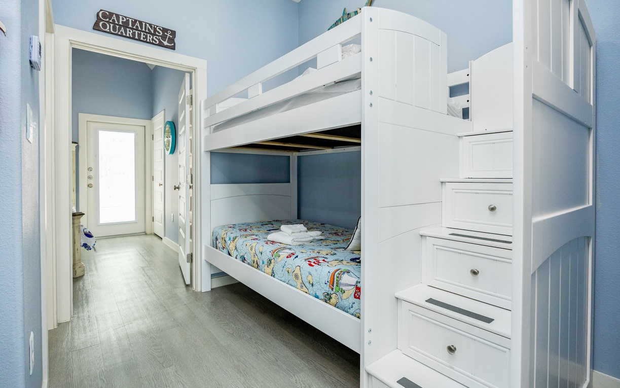 Your little sailors will love this nautical-themed bunk room with built-in storage stairs and cheerful ocean blue walls.