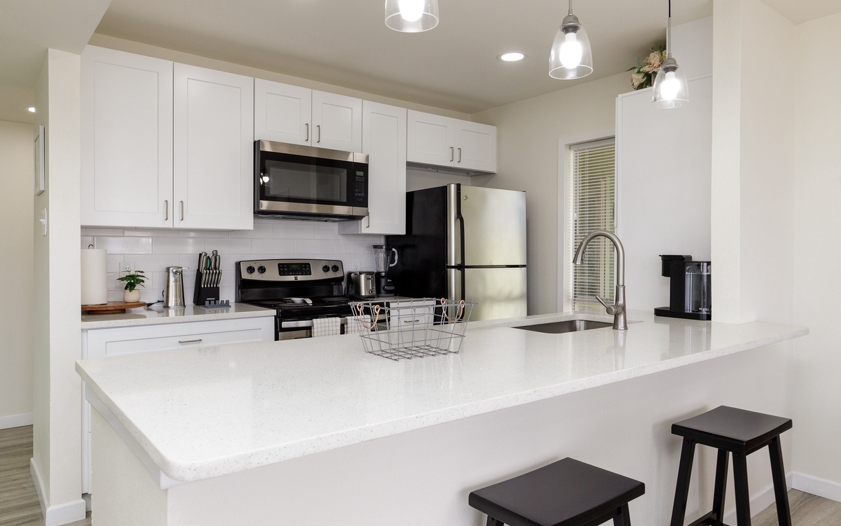Your modern kitchen features sleek white cabinets, stainless appliances, and a spacious island perfect for cooking and casual dining.