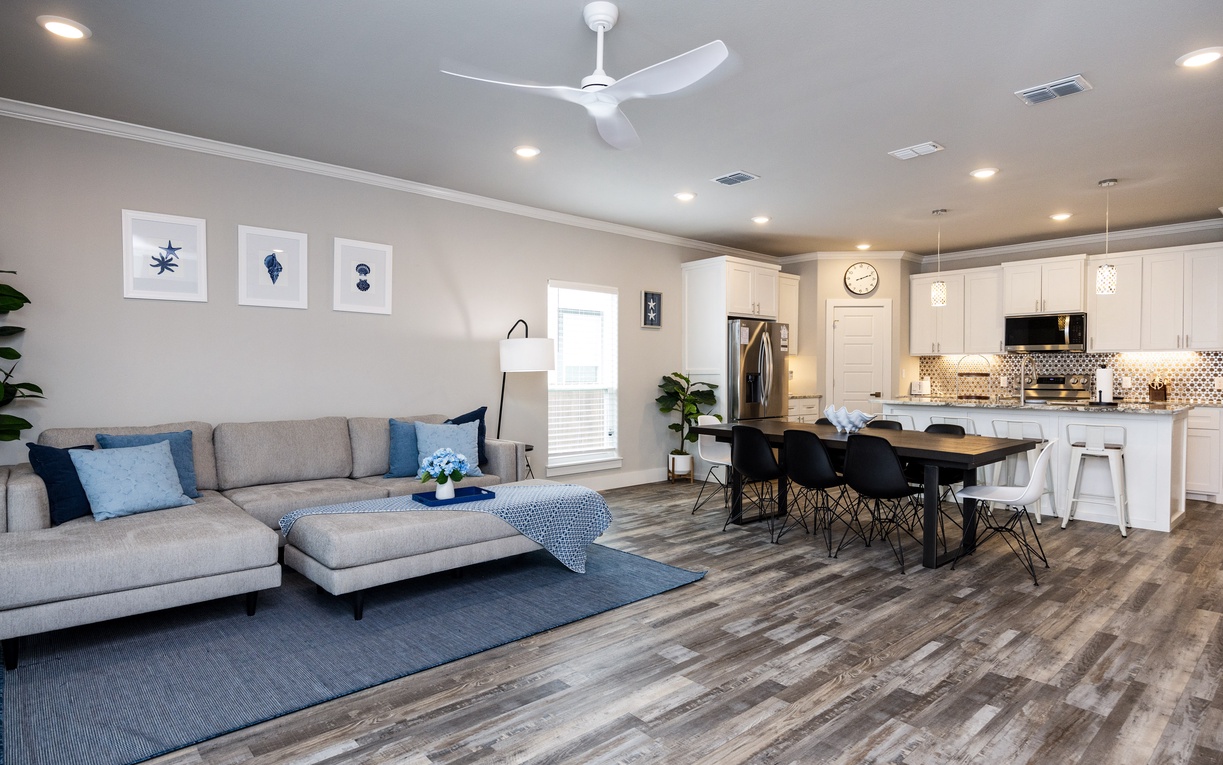 Relax in your modern open-plan living space featuring cozy seating, fully equipped kitchen, and stylish dining area perfect for memorable meals.