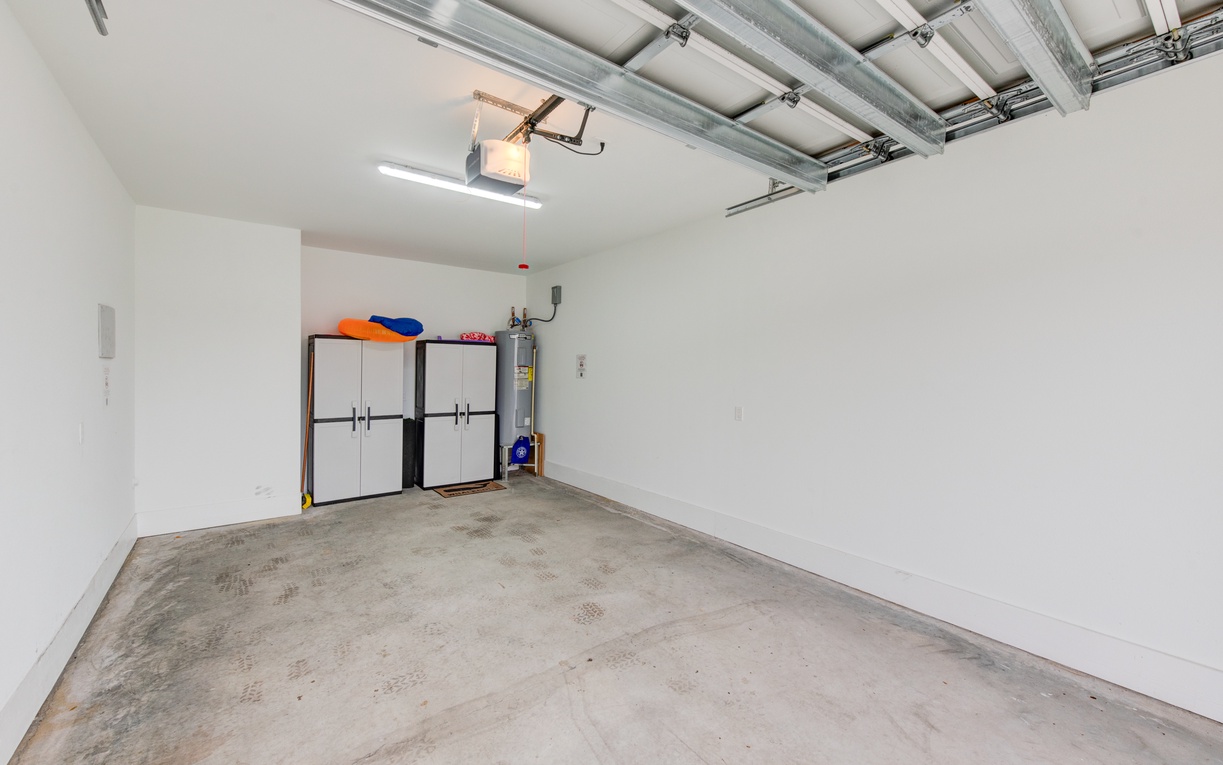 Spacious garage with convenient storage solutions and essential utilities for your comfort.