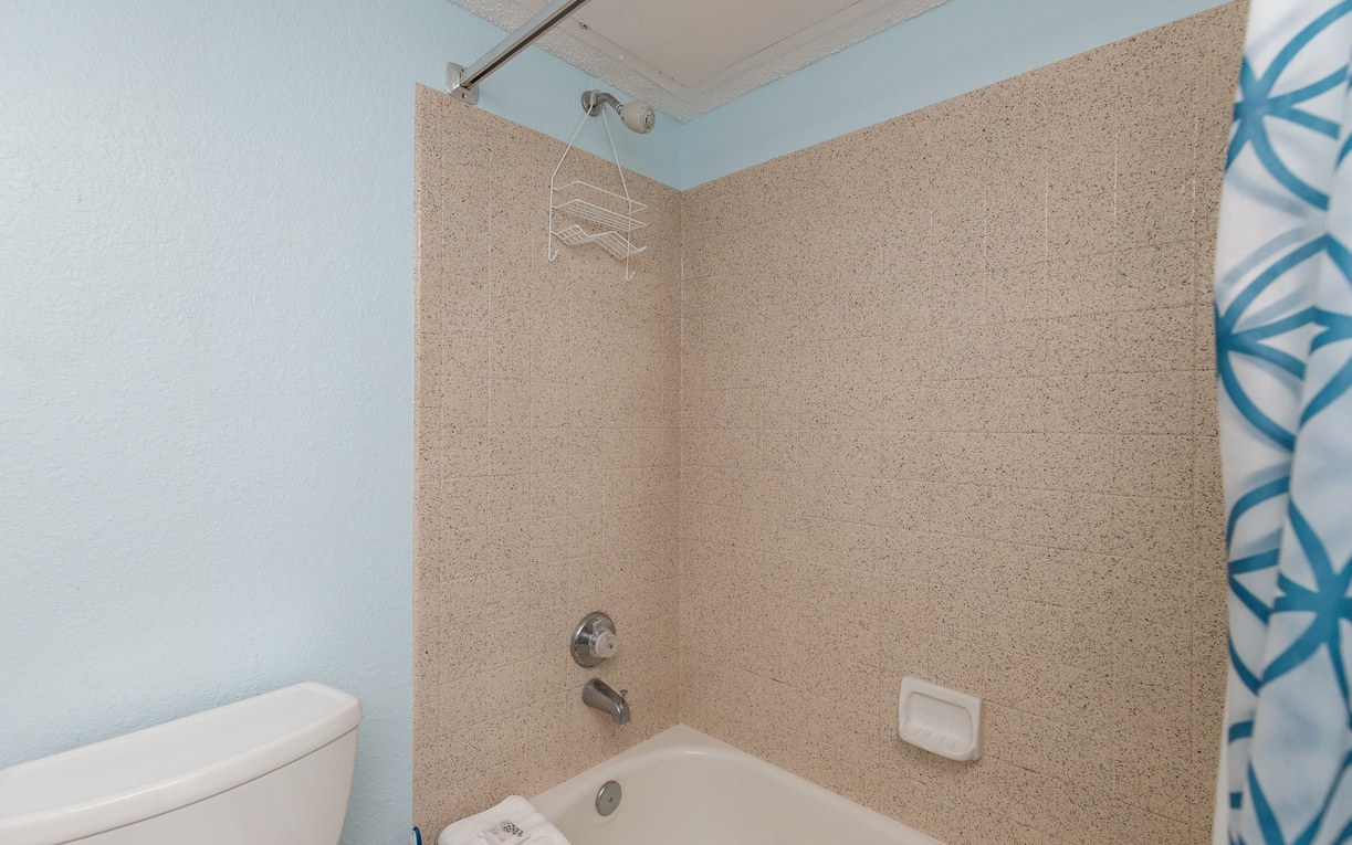 Step into your refreshing bathroom featuring a clean tub-shower combo with modern fixtures and soothing blue accents for your daily rituals.