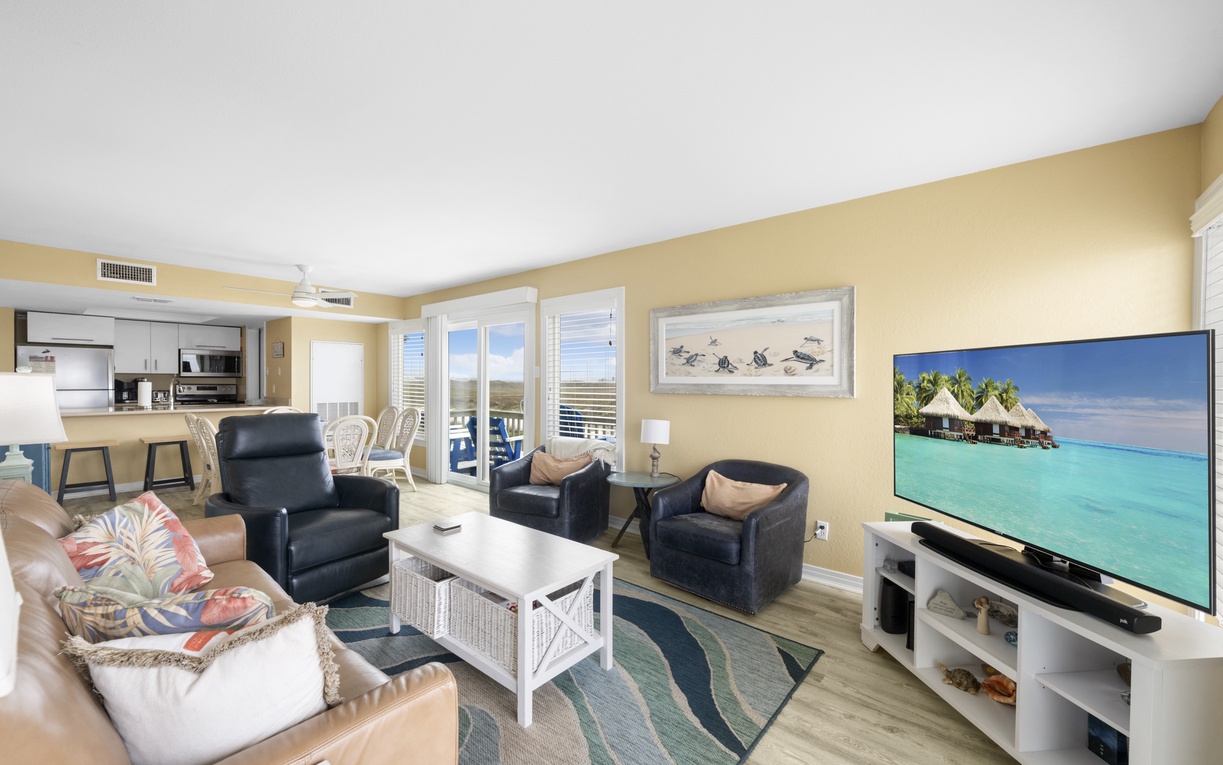 Your bright coastal living space blends comfort with ocean charm, featuring vibrant tropical accents and an open kitchen perfect for vacation gatherings.