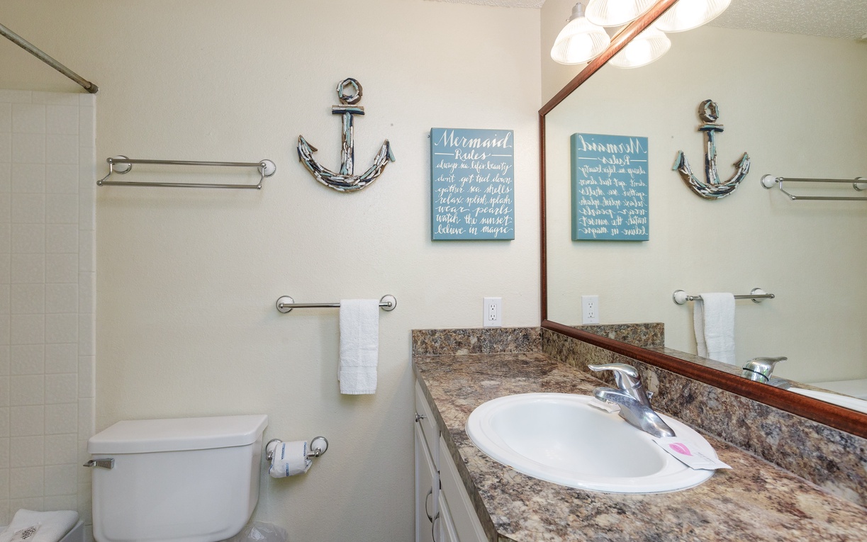 Refresh in your charming coastal-themed bathroom with granite countertops, nautical decor, and all the essentials for a comfortable stay.