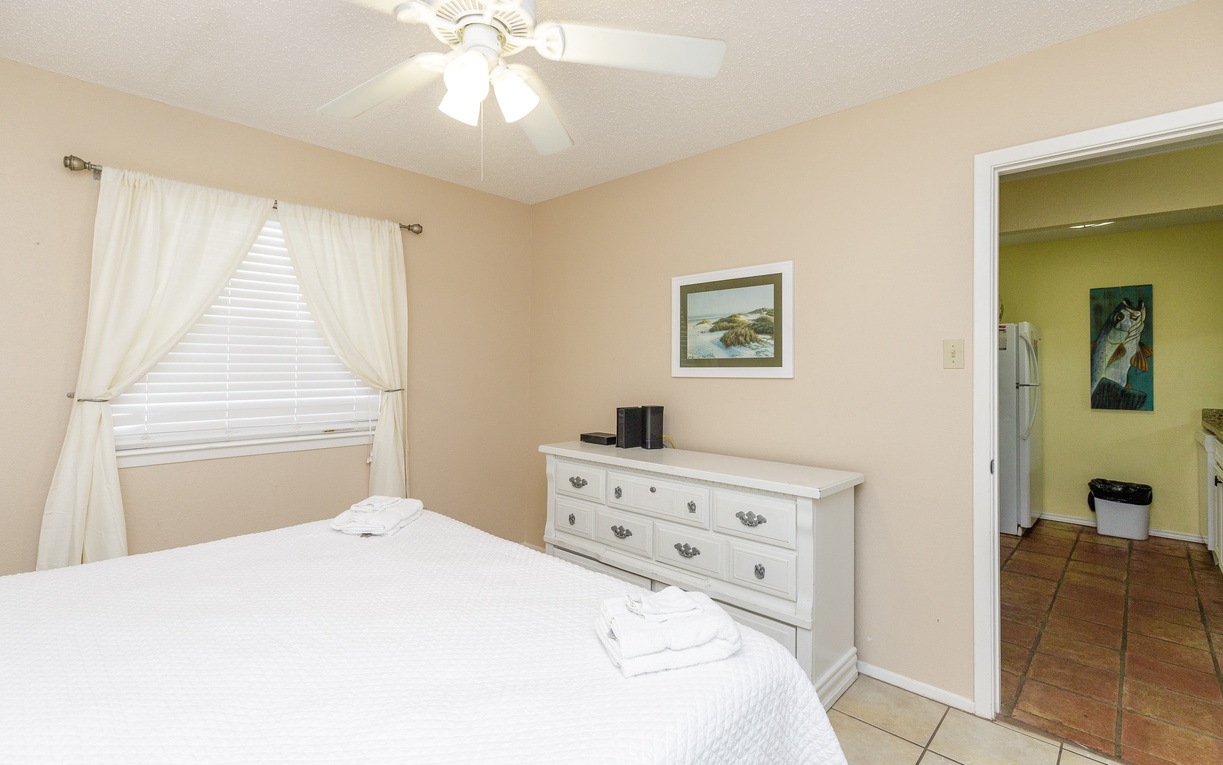 Unwind in your peaceful bedroom with crisp linens, gentle ceiling fan breeze, and natural light filtering through soft curtains.