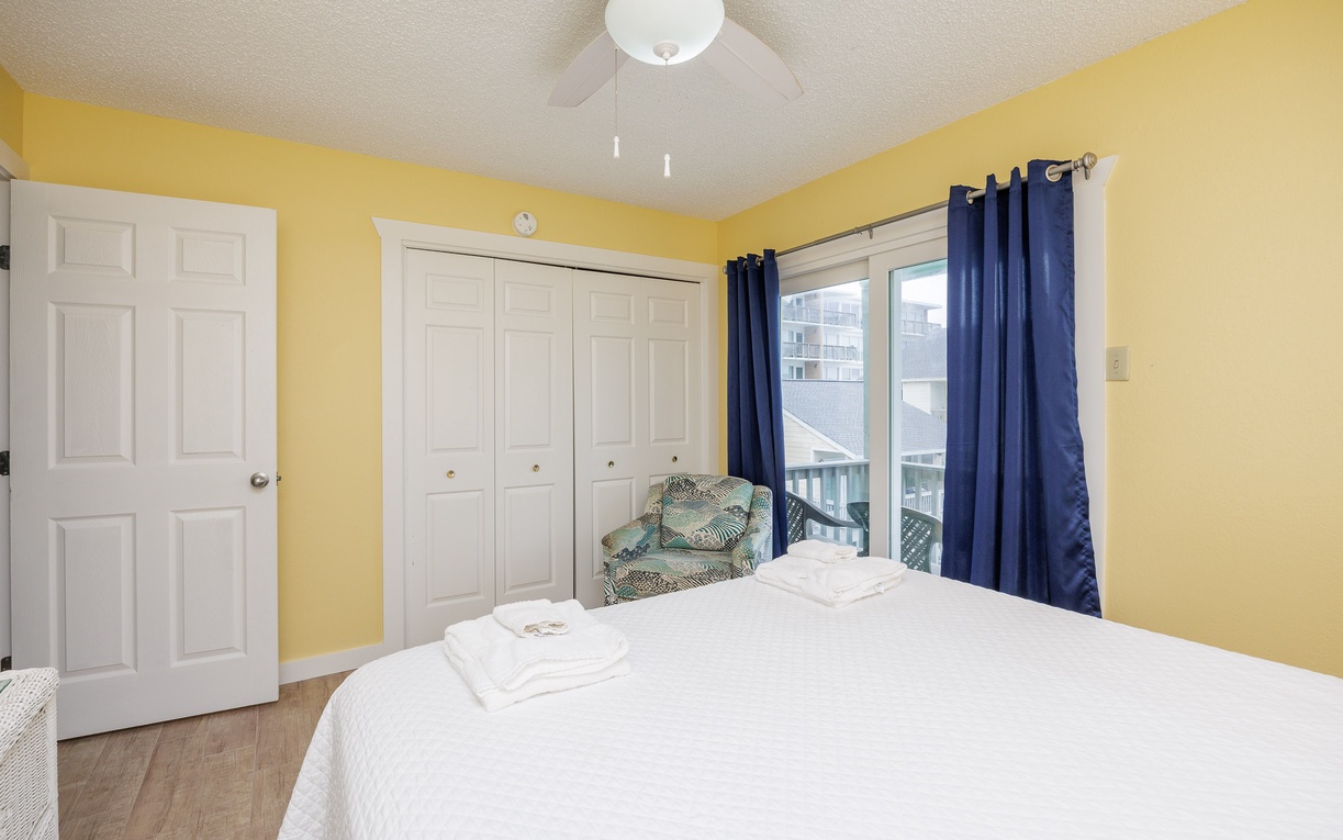 Second floor primary bedroom with queen size bed, private balcony and ensuite bathroom