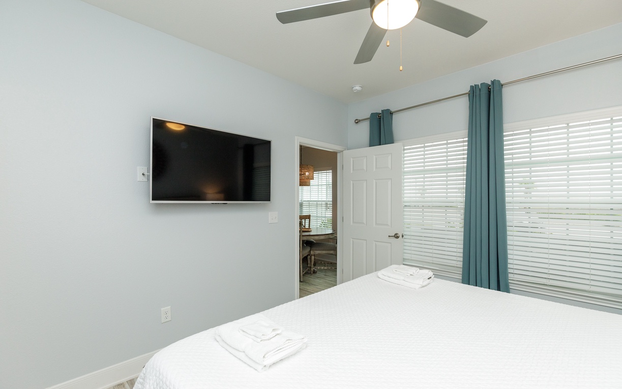 Unwind in your serene bedroom with fresh linens, gentle ceiling fan breezes, and entertainment at your fingertips.