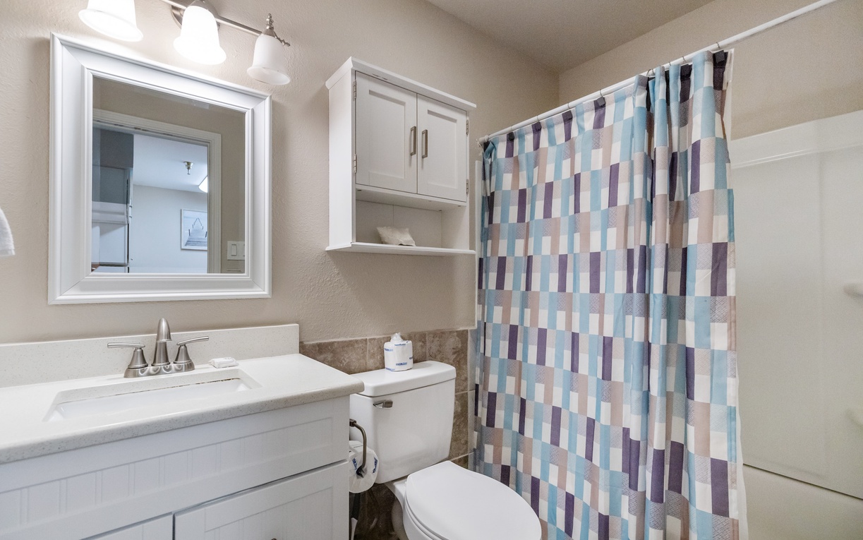 Your private bathroom features a spacious vanity, bright lighting, and colorful shower curtain for comfortable daily routines.