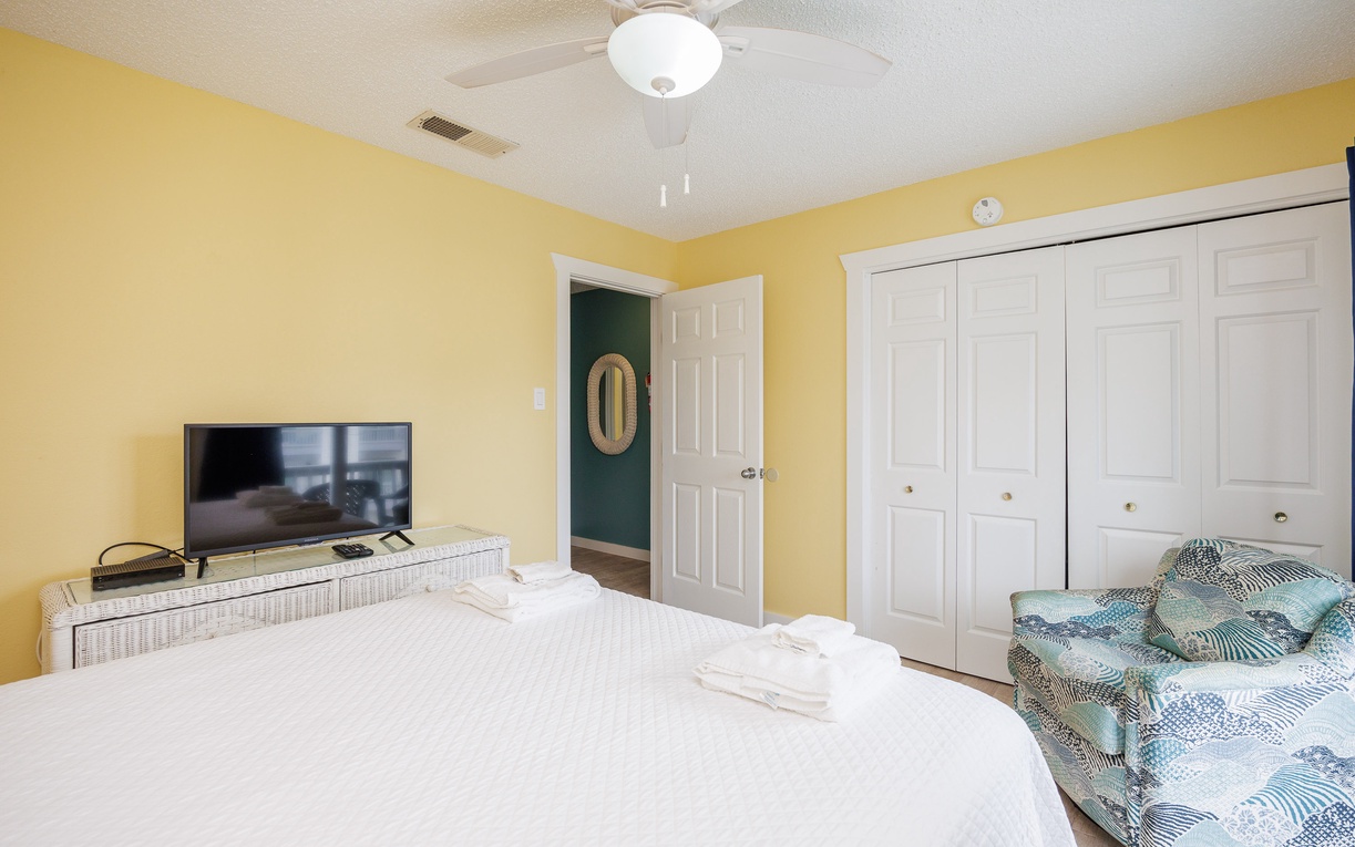 Wake up refreshed in your cheerful bedroom with sunny yellow walls, cozy white linens, and thoughtful touches like ceiling fan comfort.