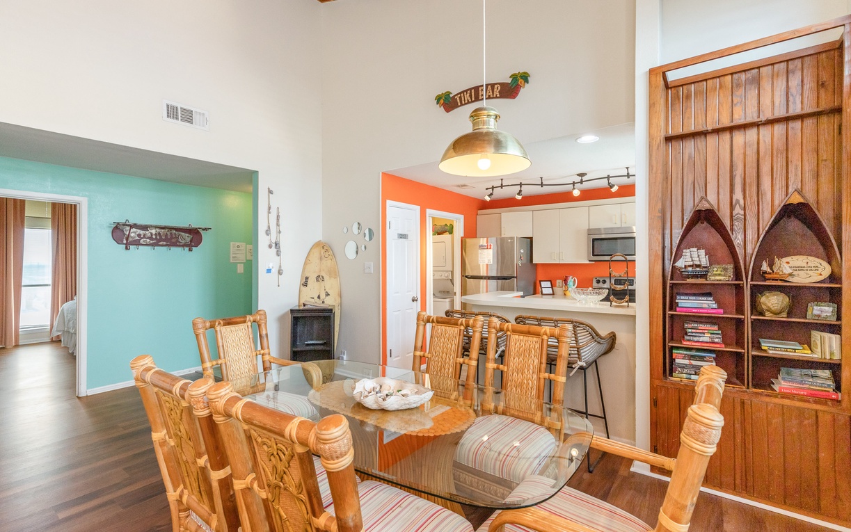 Relax in your coastal-themed living space with warm wood details, tropical decor, and a fully equipped kitchen perfect for vacation meals.