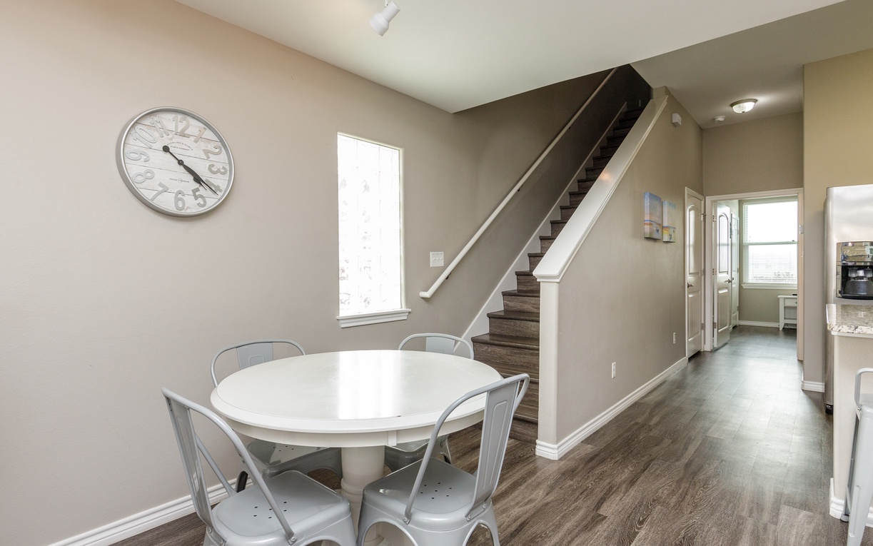 Your open dining space flows seamlessly with modern charm, featuring a bright white table perfect for morning coffee or evening meals together.