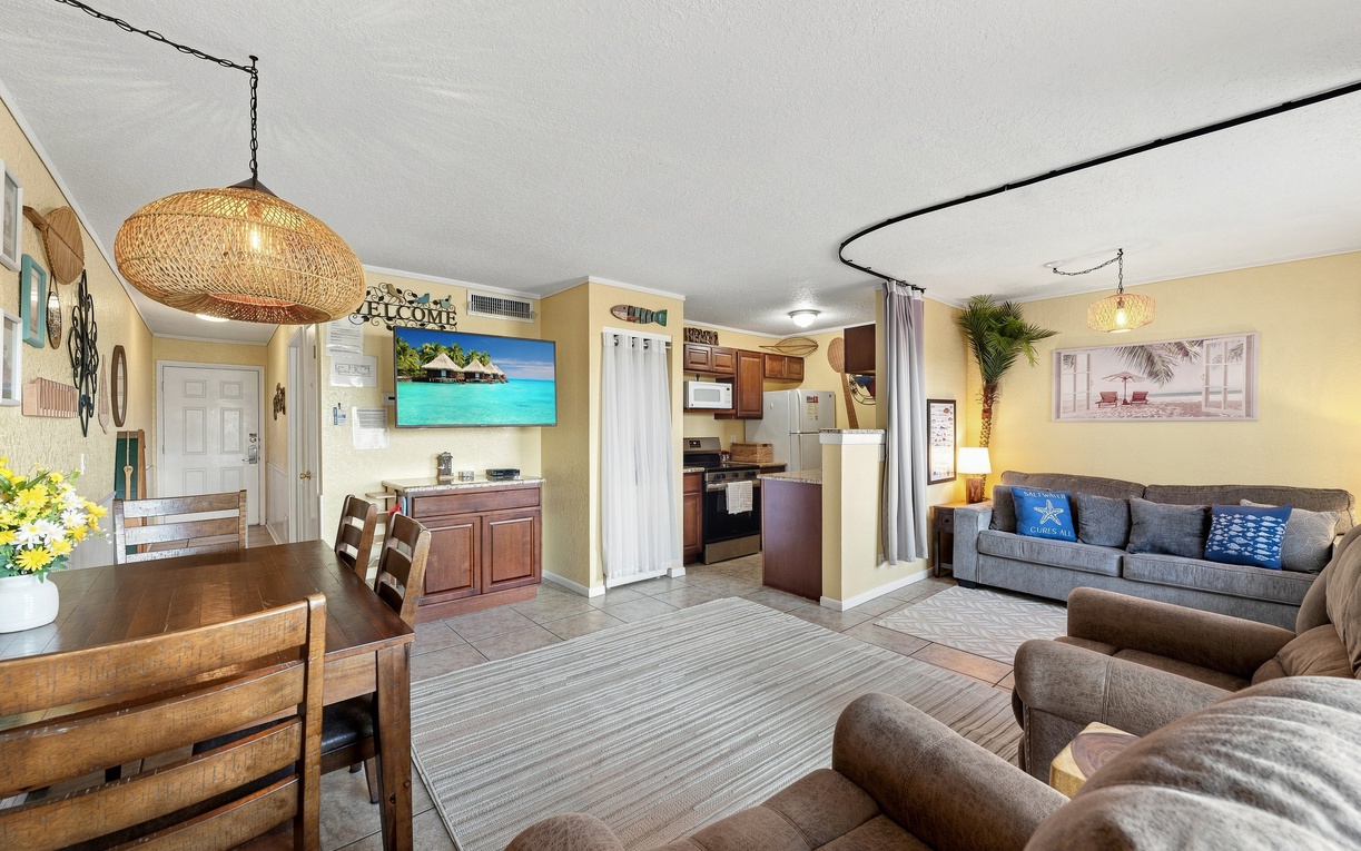 Settle into your spacious living area with plush seating, beachy decor, and an open layout that flows effortlessly into the dining space and well-equipped kitchen—perfect for gathering after a day of exploring.