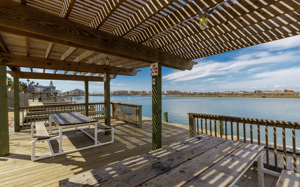 Relax under the shaded pergola while enjoying stunning lake views from this peaceful waterfront deck.