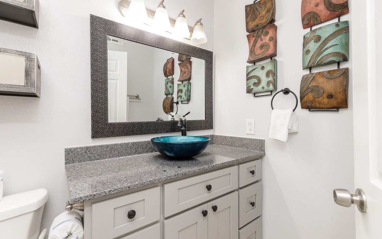 Your stylish bathroom features a striking turquoise vessel sink and artistic wall decor, creating a spa-like retreat for your daily rituals.