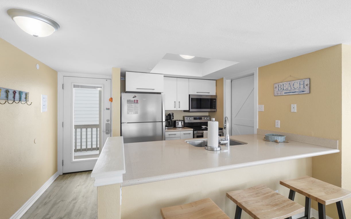 Your bright, fully-equipped kitchen features modern appliances and a breakfast bar where you can start each day with coffee and ocean views.