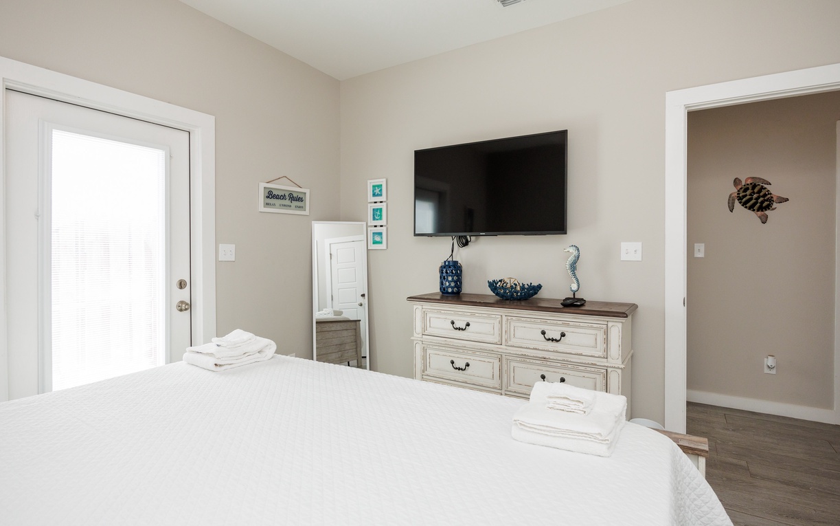 Unwind in your peaceful primary bedroom with a king size bed, crisp linens, charming nautical touches, and entertainment at your fingertips.