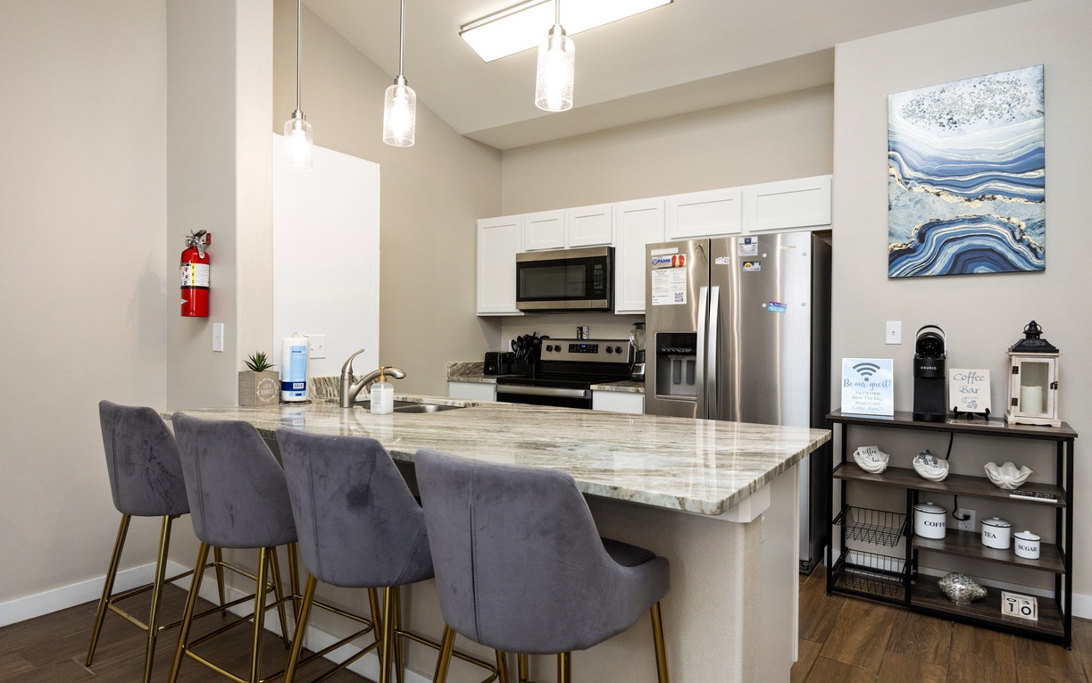Your modern kitchen awaits with sleek granite counters, stainless appliances, and stylish seating perfect for morning coffee or casual meals.