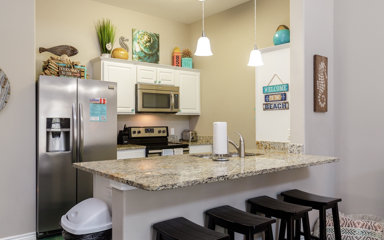 Prepare your favorite meals in this fully equipped kitchen featuring granite countertops, stainless steel appliances, and breakfast bar seating.